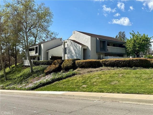 view of side of home featuring stucco siding and a lawn