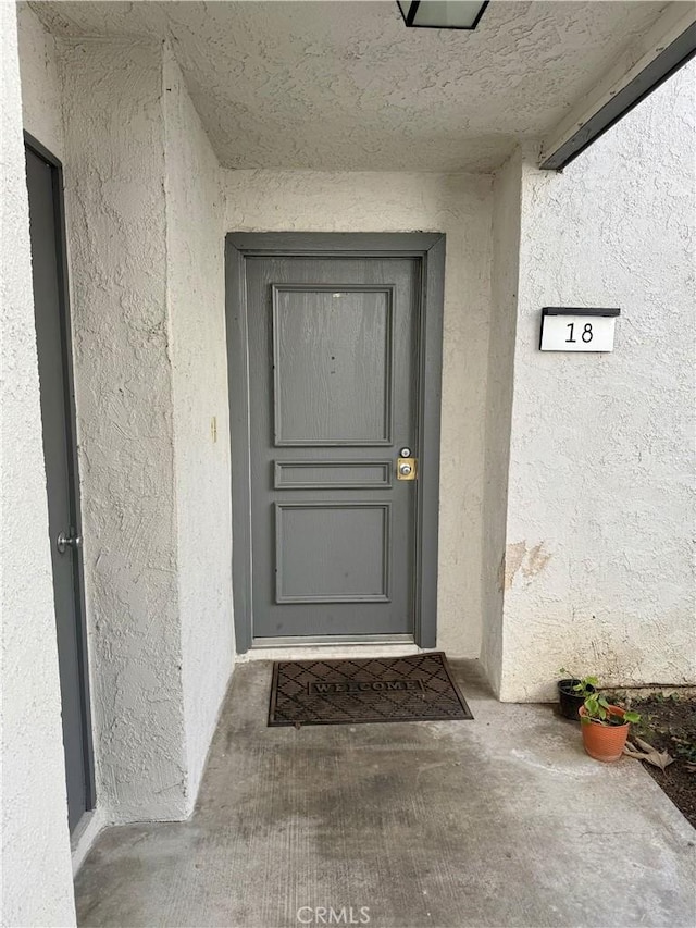 doorway to property featuring stucco siding