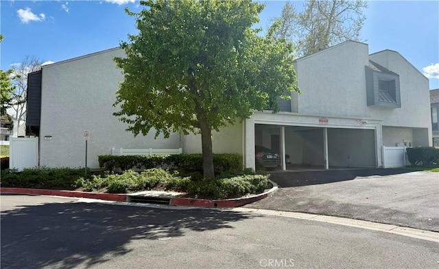 view of front of property with aphalt driveway, a garage, and stucco siding