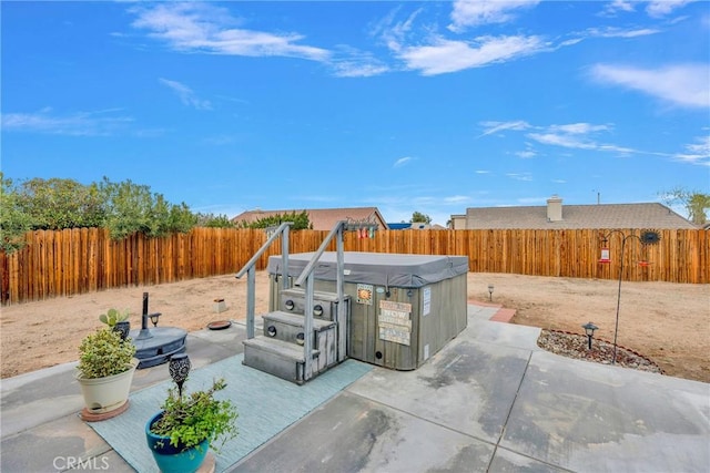 view of patio / terrace with a fenced backyard and a hot tub