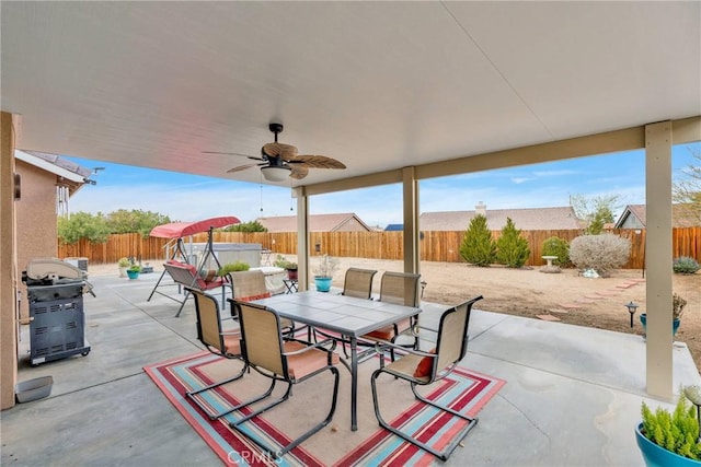 view of patio / terrace featuring outdoor dining area, a fenced backyard, a ceiling fan, and a hot tub