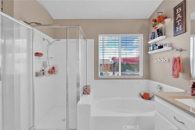 bathroom featuring a garden tub, a stall shower, and vanity