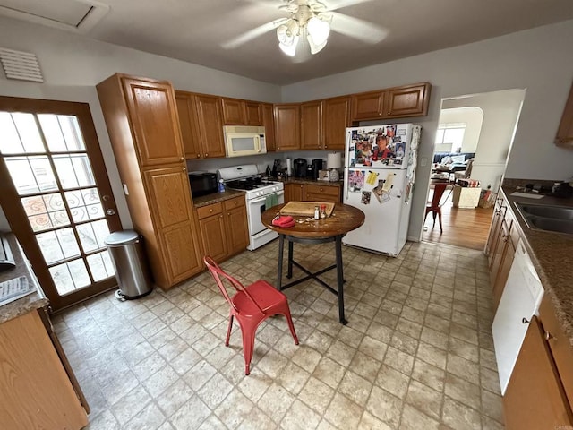 kitchen featuring a ceiling fan, white appliances, light floors, and a sink