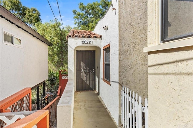 view of exterior entry featuring a tile roof and stucco siding