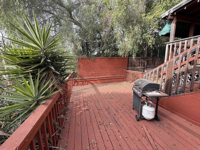 wooden terrace featuring grilling area, stairs, and fence