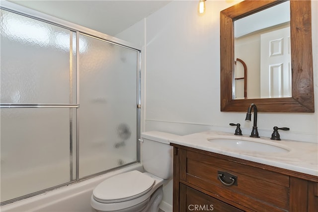 bathroom with vanity, toilet, and bath / shower combo with glass door