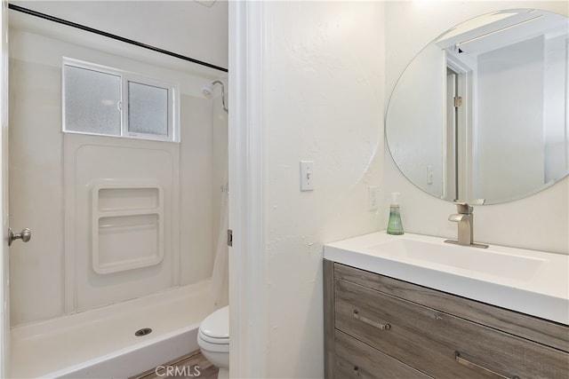 full bath featuring toilet, a stall shower, and vanity