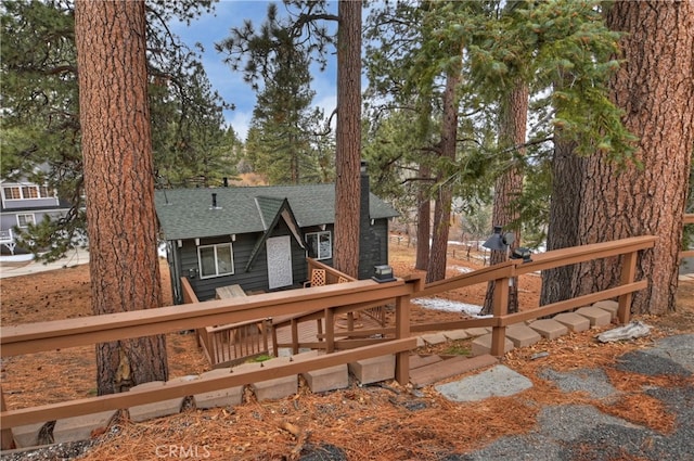 rear view of house featuring roof with shingles