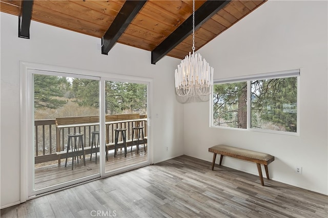 unfurnished dining area with lofted ceiling with beams, wood finished floors, wood ceiling, and a chandelier