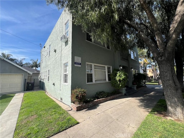 view of side of property with crawl space, a lawn, fence, and stucco siding