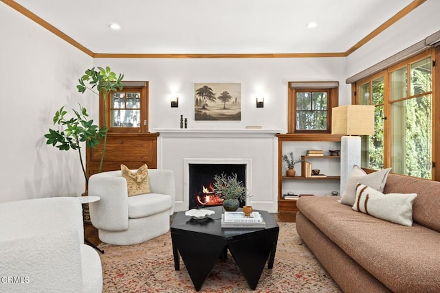 living area featuring recessed lighting, wood finished floors, a warm lit fireplace, and ornamental molding