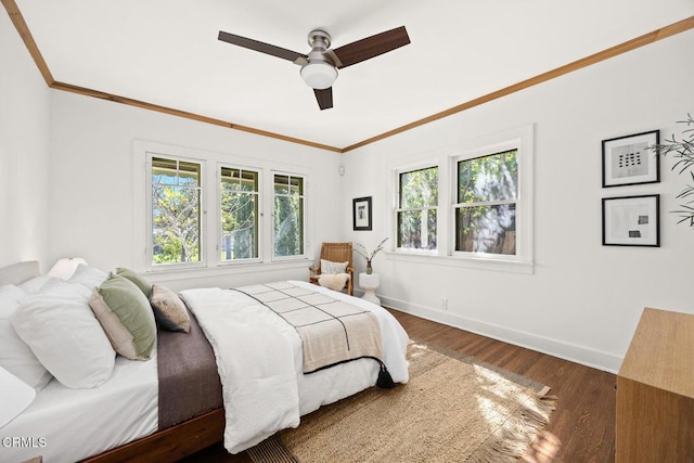 bedroom with multiple windows, wood finished floors, and ornamental molding