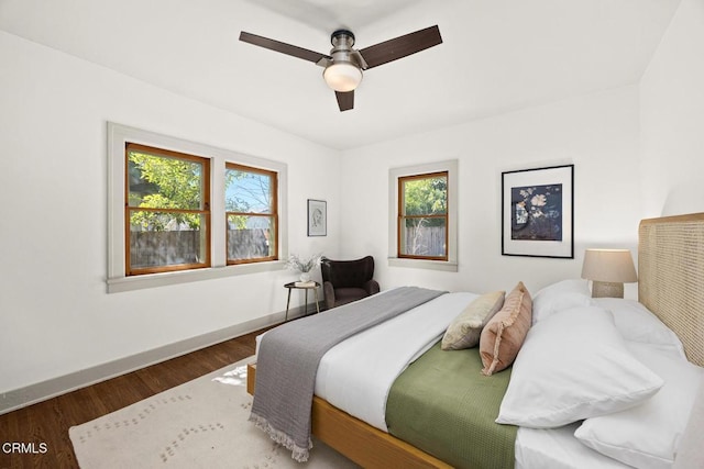 bedroom featuring a ceiling fan, wood finished floors, and baseboards