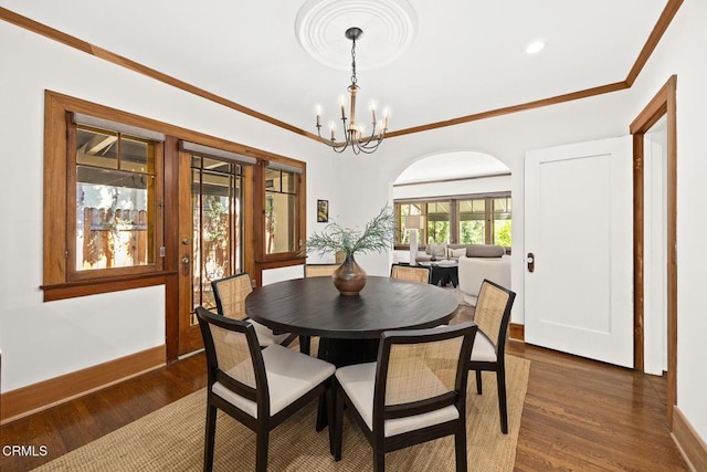 dining room featuring baseboards, a notable chandelier, dark wood finished floors, and crown molding