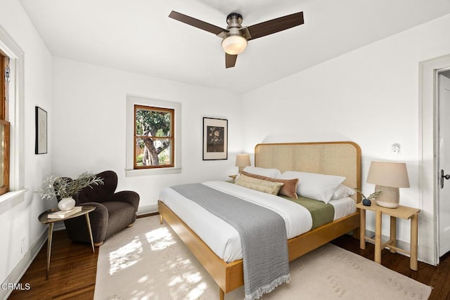 bedroom featuring baseboards, wood finished floors, and a ceiling fan