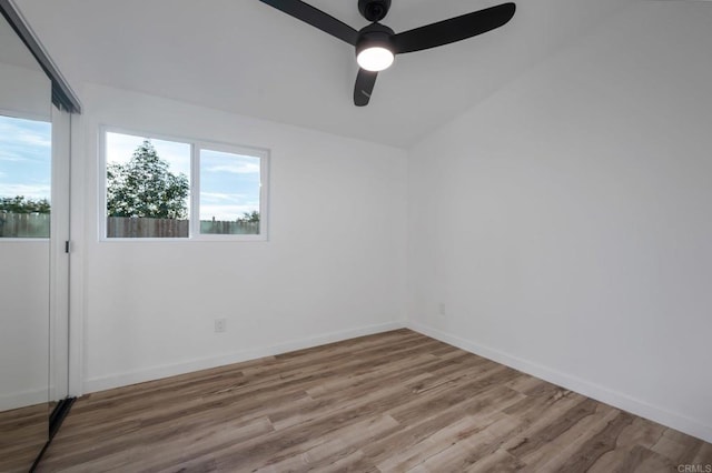 unfurnished room with a ceiling fan, wood finished floors, and baseboards