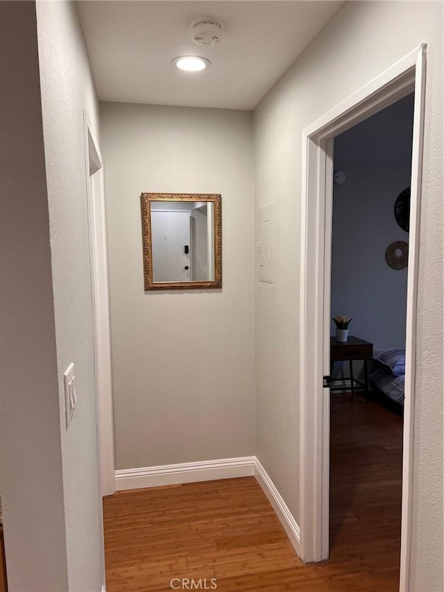 hallway featuring baseboards and wood finished floors