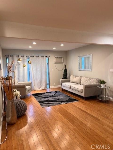 living room with recessed lighting, baseboards, an AC wall unit, and hardwood / wood-style floors