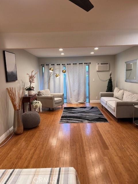 living room featuring hardwood / wood-style floors, recessed lighting, baseboards, and a wall mounted air conditioner