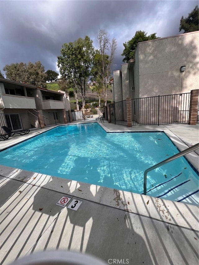 community pool featuring a patio area and fence