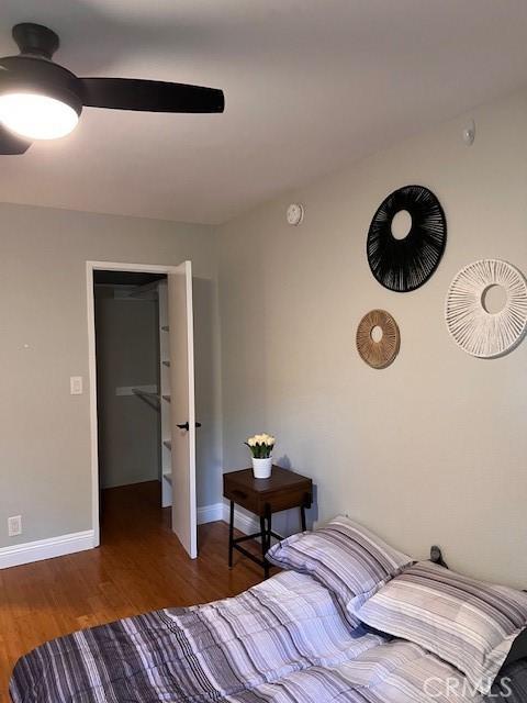 bedroom with wood finished floors, baseboards, and ceiling fan