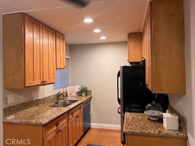 kitchen featuring a sink, light wood-type flooring, baseboards, dishwasher, and recessed lighting