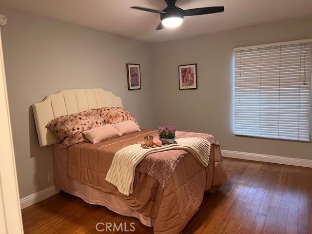 bedroom with baseboards, wood-type flooring, and a ceiling fan