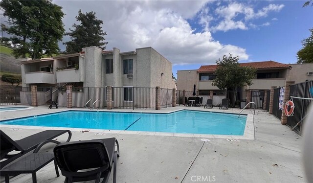 community pool featuring fence and a patio