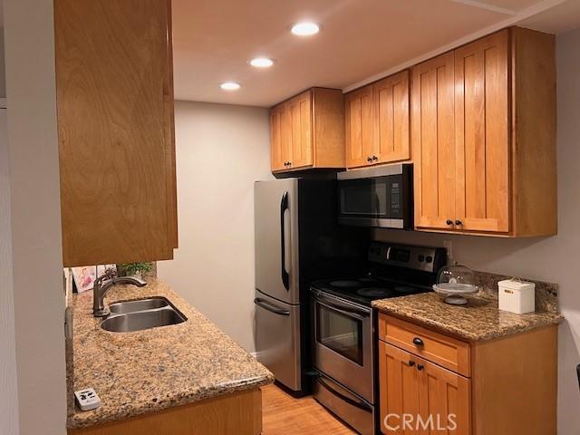 28947 Thousand Oaks Blvd Unit 134, Agoura Hills, CA 91301 - kitchen with stainless steel appliances, light wood-style floors, recessed lighting, and light stone counters