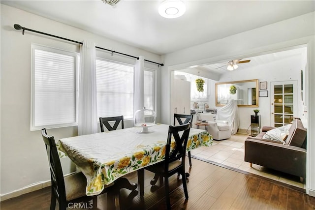 dining area with baseboards, wood finished floors, a ceiling fan, and vaulted ceiling