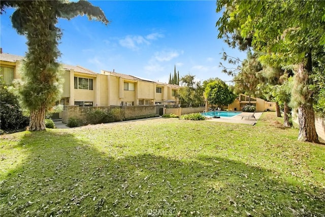 view of yard with an outdoor pool and fence