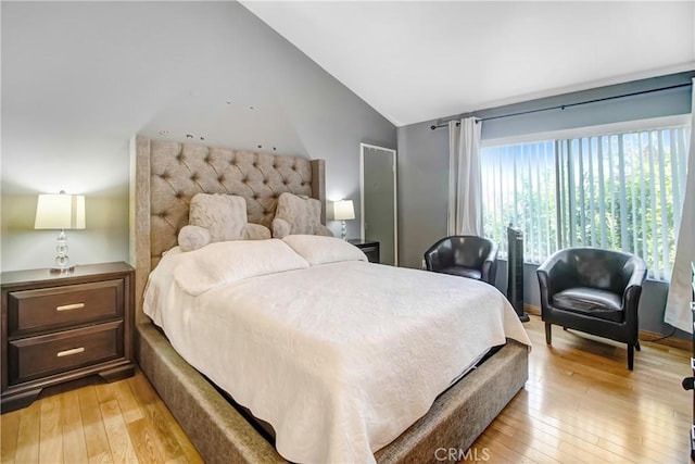 bedroom featuring light wood-type flooring and vaulted ceiling