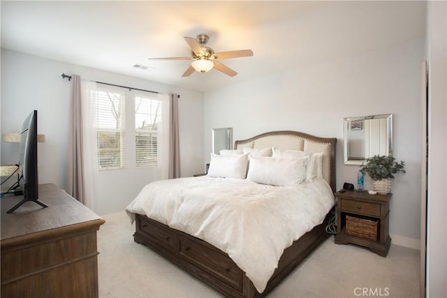 bedroom with visible vents, light colored carpet, and a ceiling fan