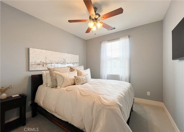 carpeted bedroom with visible vents, baseboards, and a ceiling fan