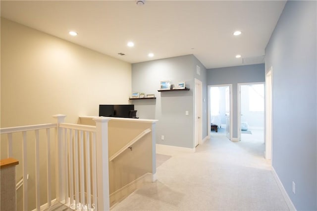 hall with recessed lighting, baseboards, an upstairs landing, and light carpet