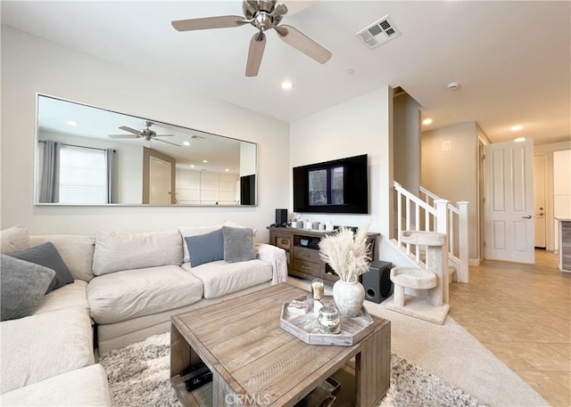 living area with light tile patterned flooring, visible vents, recessed lighting, and stairway