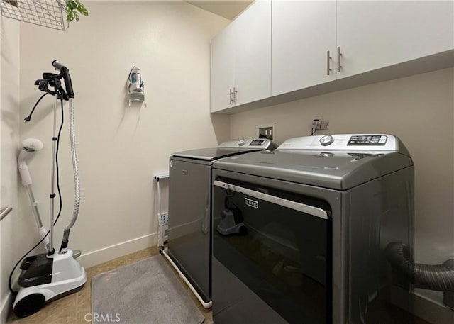 washroom with washer and clothes dryer, cabinet space, and baseboards