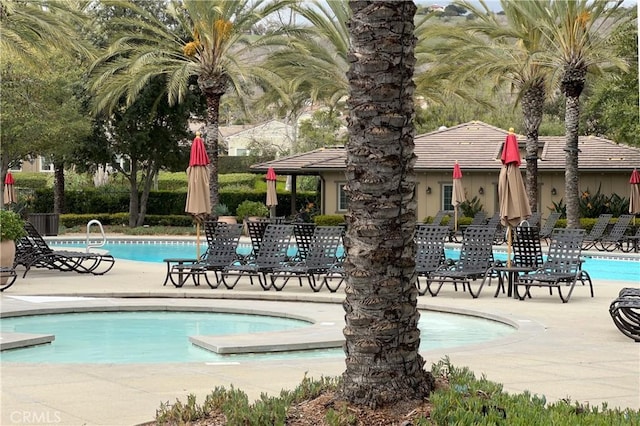 community pool with fence and a patio area