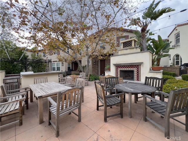 view of patio featuring exterior fireplace and outdoor dining space