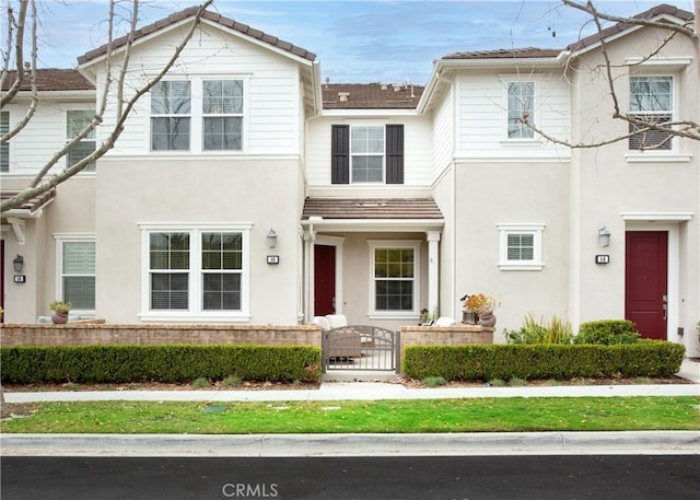 view of front facade featuring stucco siding and a fenced front yard