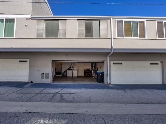 exterior space with a garage and stucco siding