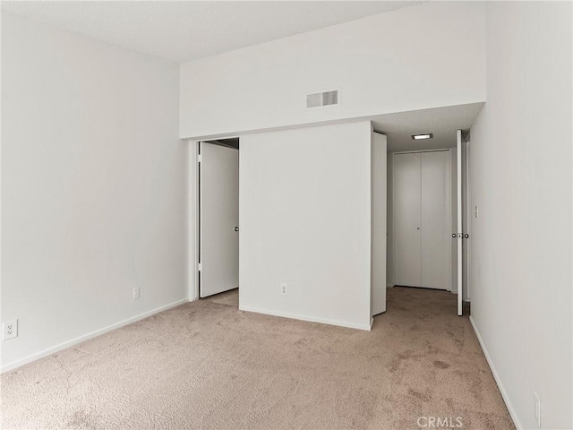 unfurnished bedroom with visible vents, baseboards, and carpet flooring