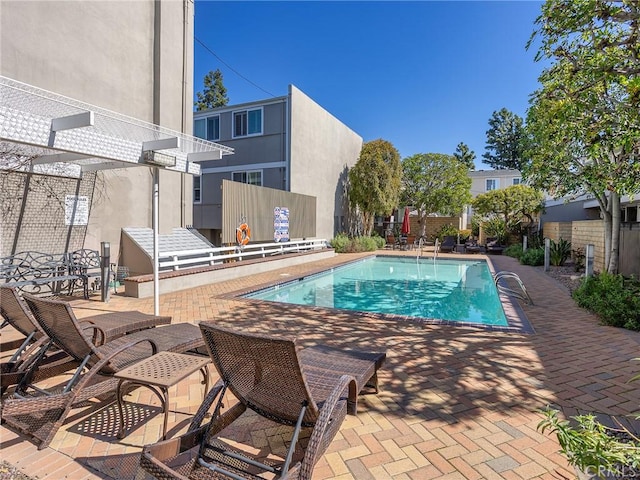 pool with a patio area and a pergola