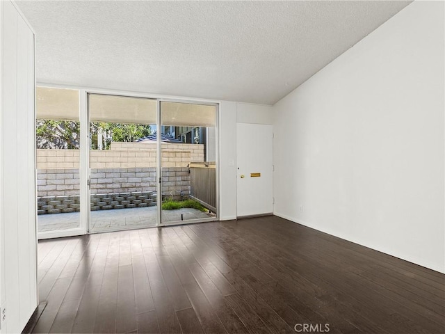 unfurnished room featuring expansive windows, a textured ceiling, and wood finished floors