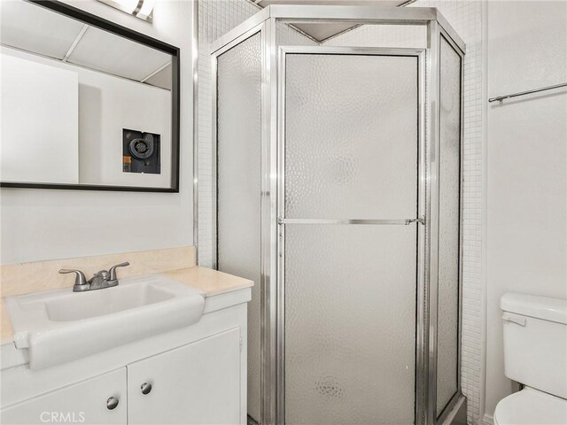 bathroom featuring vanity, toilet, and a stall shower