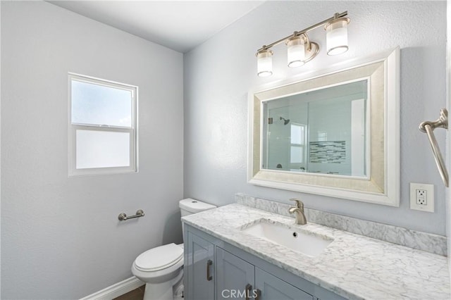 bathroom featuring an enclosed shower, baseboards, toilet, and vanity