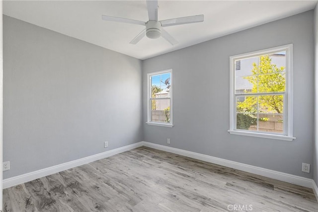 empty room featuring a ceiling fan, wood finished floors, and baseboards