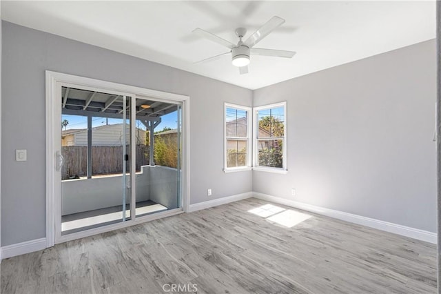 spare room featuring wood finished floors, baseboards, and ceiling fan