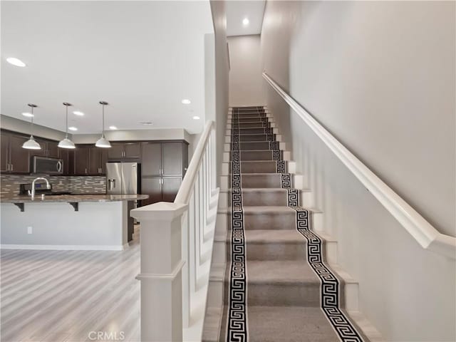 stairs featuring recessed lighting and wood finished floors