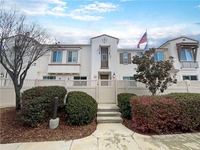 view of front of property featuring stucco siding and fence